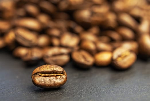 Roasted coffee beans background on a stone table. Horizontally.