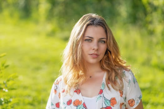 Atractive beautiful  young woman is posing outdoors. Horizontally.