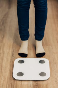 Modern Electronic Device. Girl Measures Weight on Smart Scales.