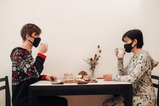 Girl and Guy Have Breakfast at Home in Masks.
