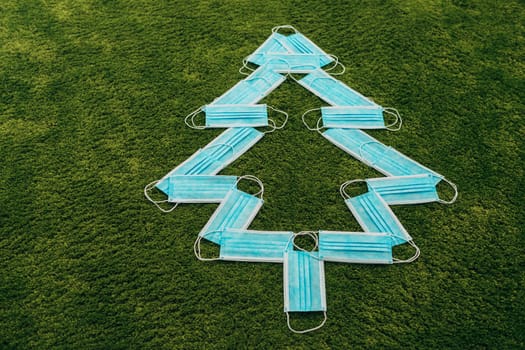 Christmas Tree Made of Medical Masks on a Green Background