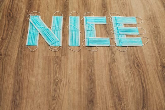 Capital Letters Nice Composed of Medical Masks on a Brown Background