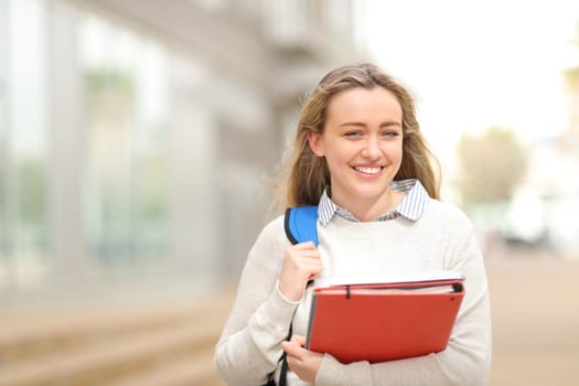 Happy student walking in the street