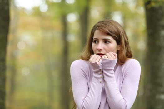 Scared woman looking at side alone in a park