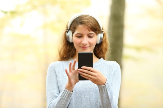 Front view of a woman listening to music in a park