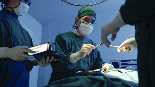 Medical surgical doctor team performing surgery patient, Group surgeon at work on operating room with electrocautery equipment for cardiovascular emergency surgery center in hospital