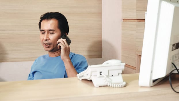 Nurse man sitting in counter bar office calling smartphone talking to patient, Nurse using phone call to family while taking a break in hospital, Medicine healthcare and pandemic concept