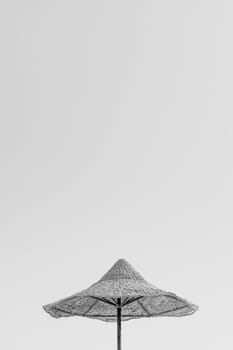 Looking up at wooden straw umbrella or thatched hut from below against beautiful cloudy blue sky view on tropical Egypt beach. Summer or winter holiday concept. Egyptian resort. Black and white photo