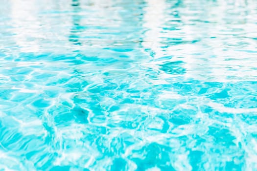 Vibrant blue white swimming pool ripped water surface with waves and nice sun sparkles. Conceptual abstract texture background. Travel or vacation summer concept. High quality photo