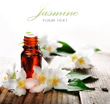 Essential oil with jasmine flower on wooden plank