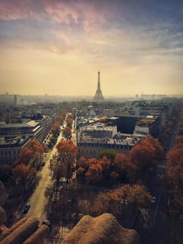 Aerial cityscape view from the top of triumphal arch to the Paris city, France. Travel concept vertical background. Autumn season sunset scene with Eiffel tower on the horizon