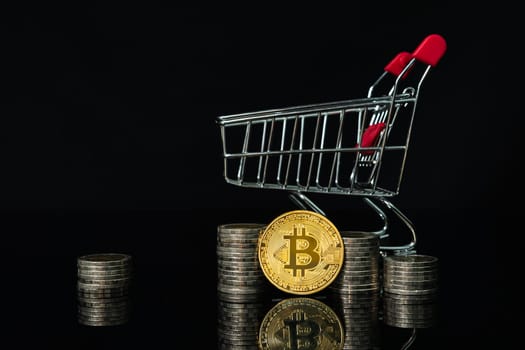 Close up Bitcoin coin and coin in shopping cart with black background