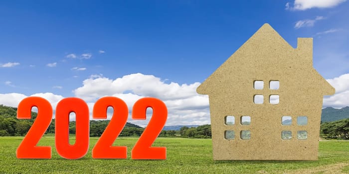 House model and number 2022 with landscape back background for finance and banking concept
