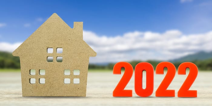 House model and number 2022 with landscape back background for finance and banking concept