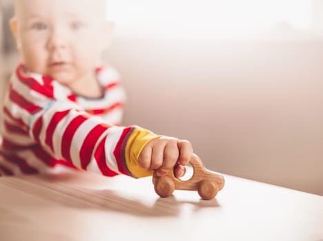 Little boy playing with wood car indoor. Concept of family travel.
