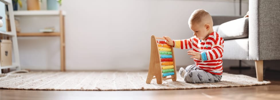 Cute child sitting on the floor in the room and playing with toys. Concept of the family relationship.