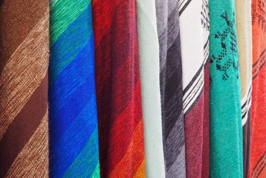 Colourful textile scarfs or blankets displayed on street market in Fes, Morocco - closeup detail.