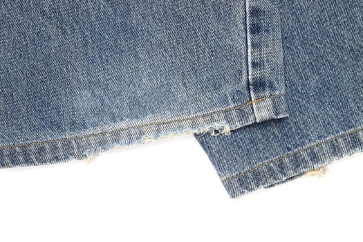 close up of old blue denim jeans hem isolated no white background