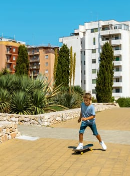 Preschooler kid boy in blue t-shirt learning to ride a skateboard outdoors. Cute child doing sports and having fun in park. Active hobbies, healthy lifestyle concept. T-shirt mockup