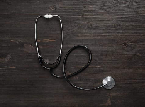 Medical stethoscope on wood table background. Flat lay.