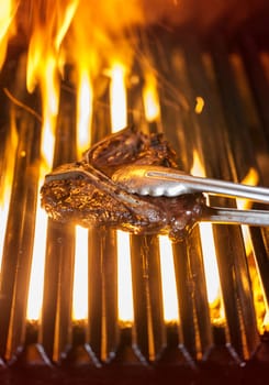 T-bone steak on the barbecue being turned around