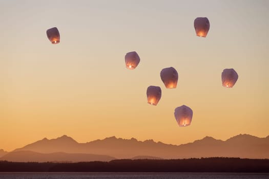 A group of flying lanterns being released into the nightsky.