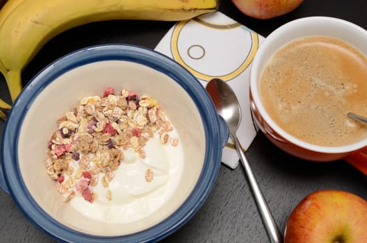 Healthy muesli with fresh fruits on a dark kitchen table