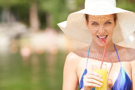 Restful young female drinking orange juice outdoors