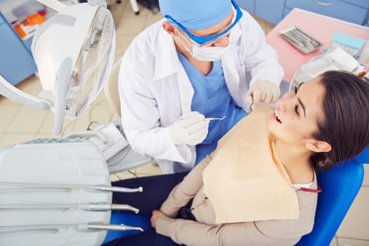 Young woman sitting at the dentist’s and having checkup