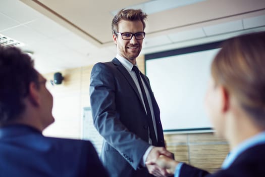 Elegant employee in suit and eyeglasses greeting businesswoman at conference