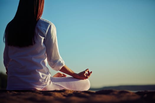 Back of peaceful woman meditating outside
