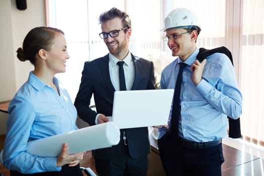 Group of happy colleagues communicating in office