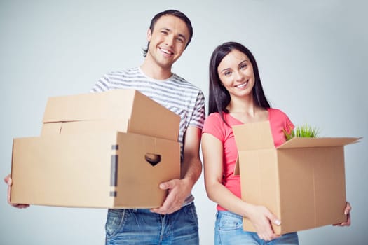 Happy young couple with boxes looking at camera