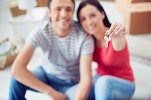 Young couple showing key from their house