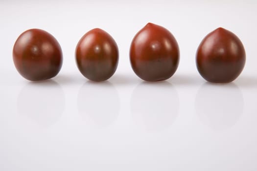 Dark green cherry tomatoes. Isolated over white background