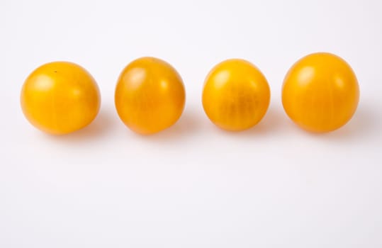 Yellow shiny cherry tomatoes. Isolated over white background