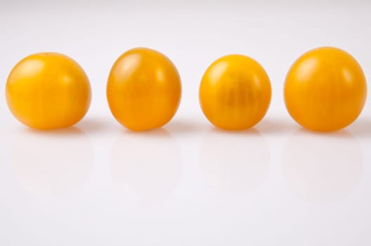 Yellow shiny cherry tomatoes. Isolated over white background