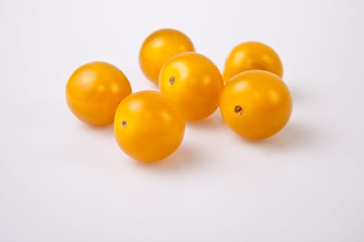 Yellow shiny cherry tomatoes. Isolated over white background