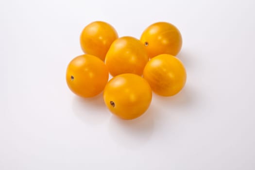 Yellow shiny cherry tomatoes. Isolated over white background