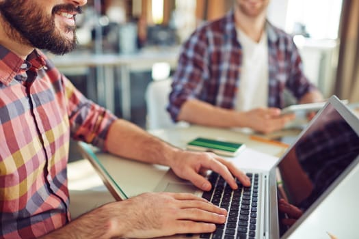 Close-up of young businessman computing in office
