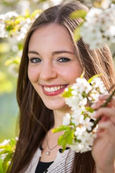 Portrait of a young woman in spring amid cherry blossoms