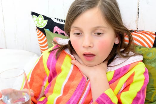 a little girl has a sore throat in her bed