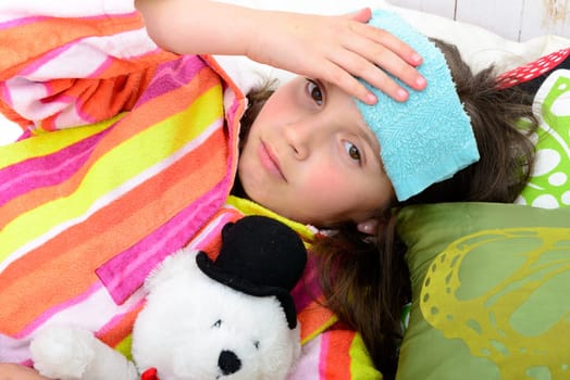 a little girl in her bed has a headache