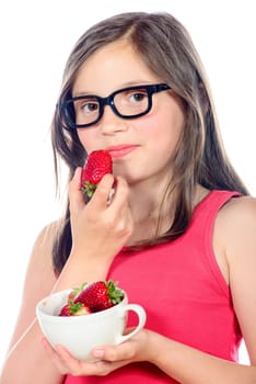 a little girl eating a strawberry