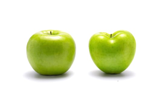Two green apples, one heart shaped. On white background with dropped shadow.