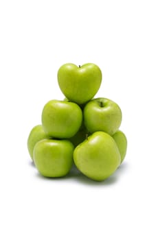 Green apples stacked in group with one heart shaped on the top. On white background.