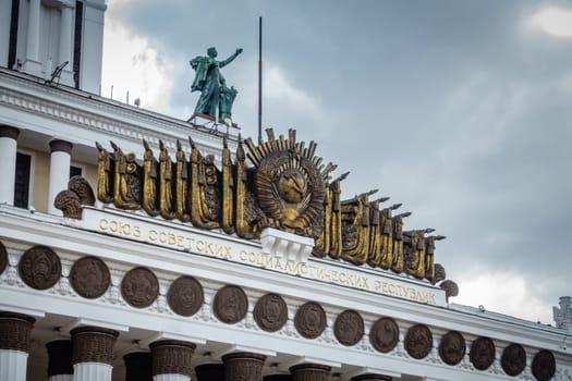 Moscow, Russia, April 23, 2016: Soviet Coat of Arms and other symbols on the Central Pavilion of the Exhibition of Achievements of National Economy in Moscow, Russia