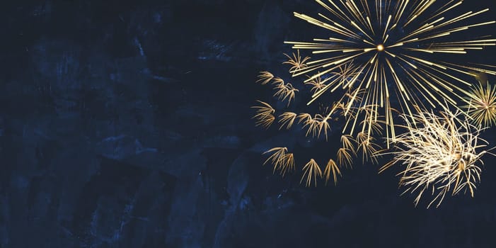 New year background banner panorama image of golden firework sparklers on dark blue night sky texture with copy space for text