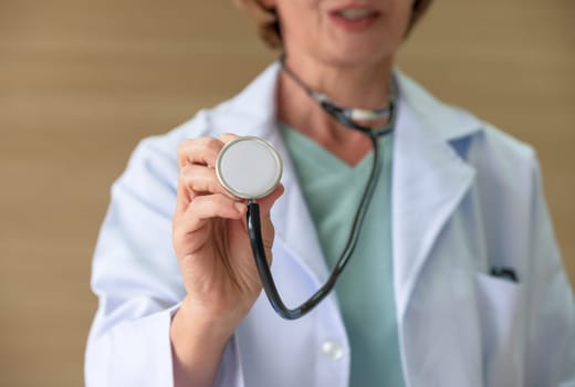 Cropped of female doctor in white coat uniform using medical stethoscope . Healthcare and insurance concept