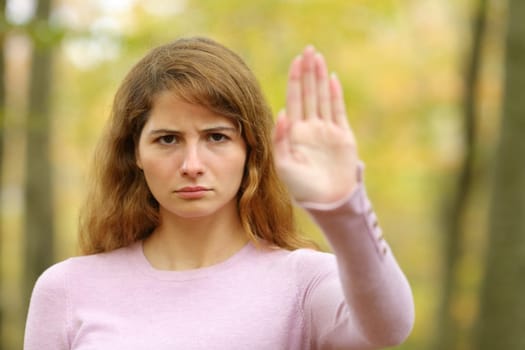 Angry woman gesturing stop in a park
